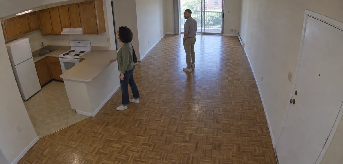 A couple looking at a kitchen, seen by the camera